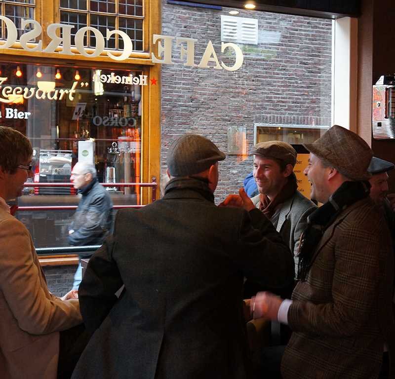 Gasten voor de ramen van Café Corso